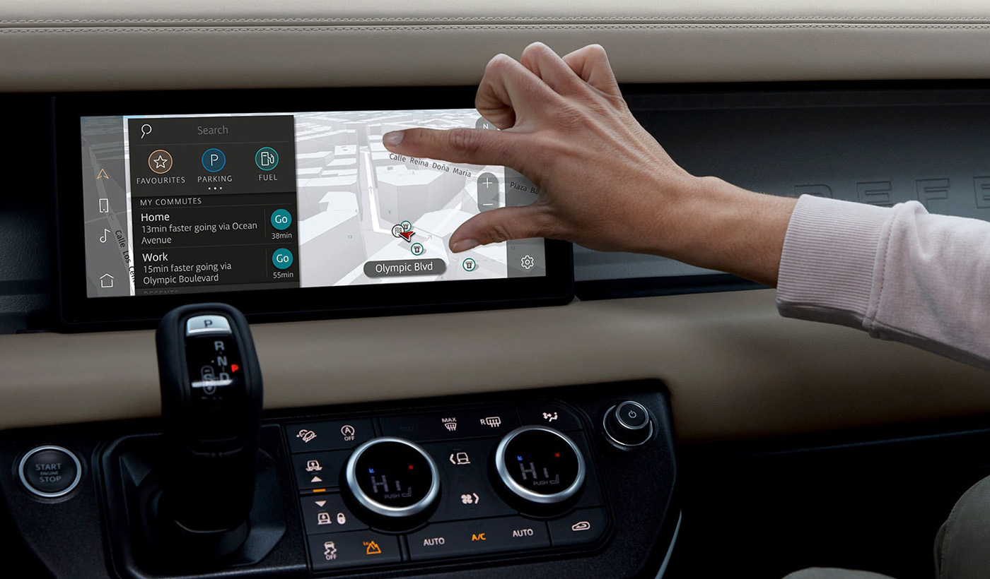 a hand interacting with a touchscreen map in a vehicle